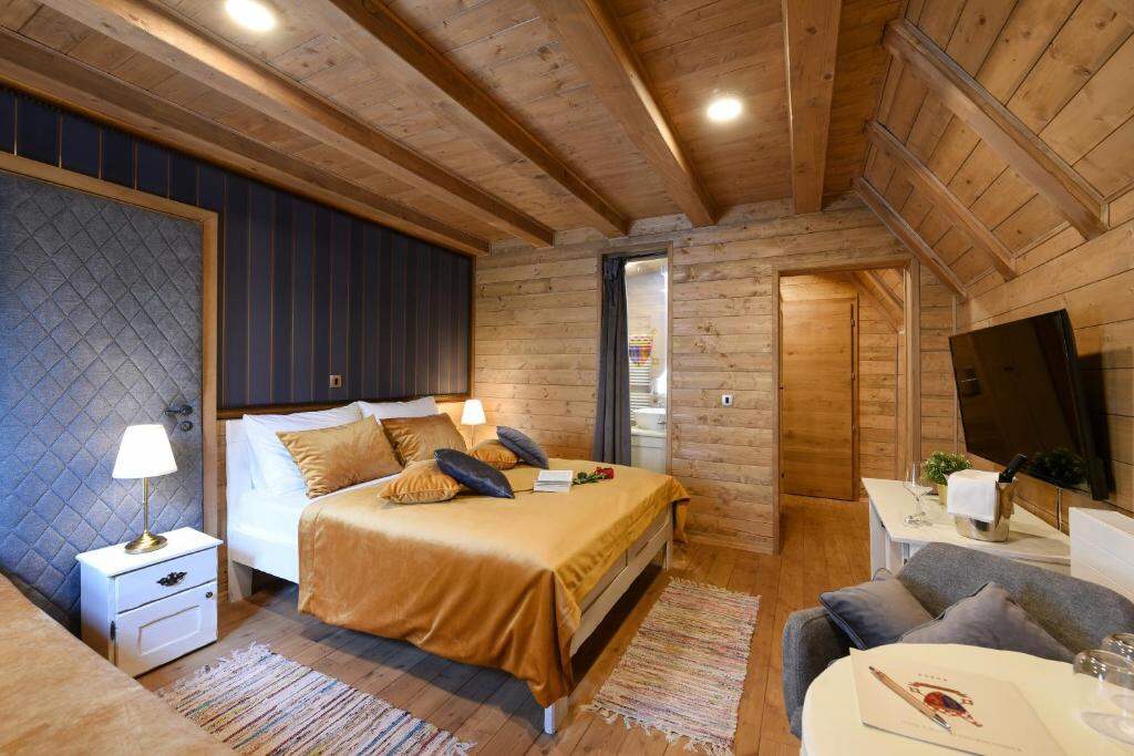 Spacious wooden room with a golden bedspread and seating area