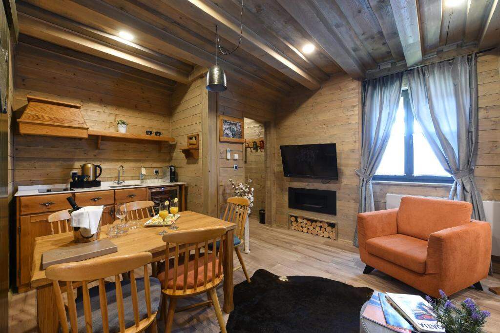 Living room with kitchenette, dining table and fireplace